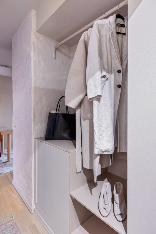A white closet with shoes and a handbag
